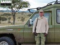 Safariguide vid jeep. (Centrala Serengeti National Park, Tanzania)